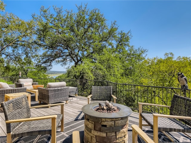 wooden terrace featuring an outdoor living space with a fire pit