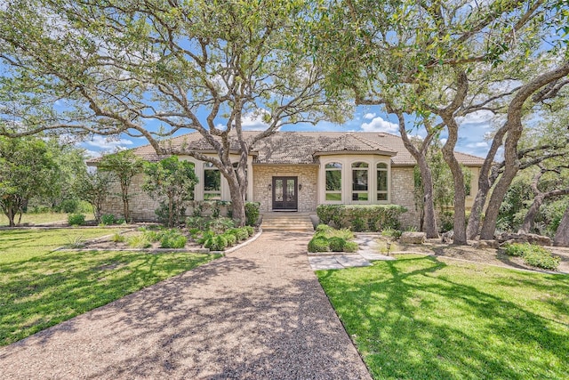 mediterranean / spanish home with a front lawn