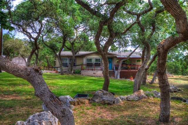 exterior space featuring a storage shed, covered porch, and a front yard