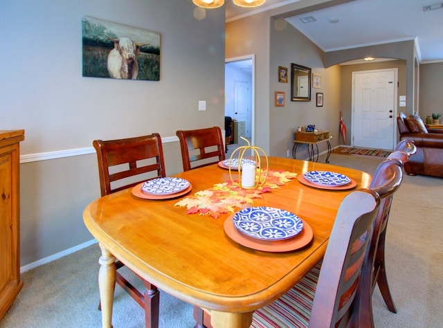 carpeted dining room featuring vaulted ceiling