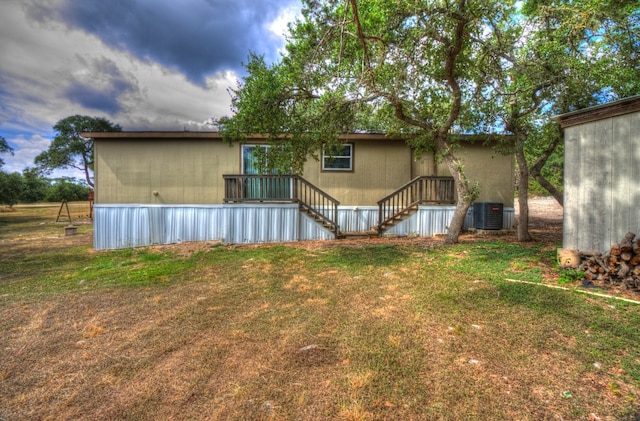 rear view of property with cooling unit and a yard