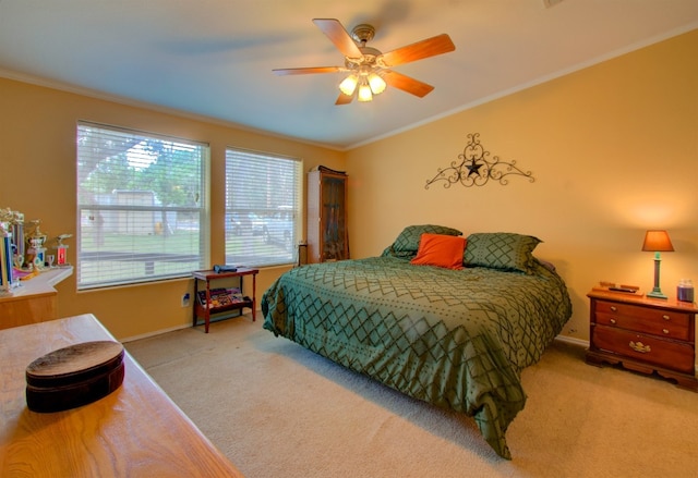 bedroom with crown molding, ceiling fan, and light colored carpet