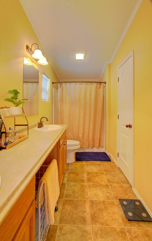 bathroom featuring vanity, toilet, ornamental molding, walk in shower, and tile patterned flooring