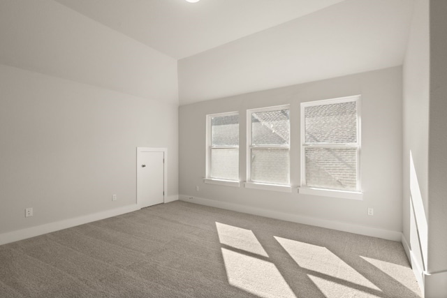 unfurnished room featuring light colored carpet and lofted ceiling