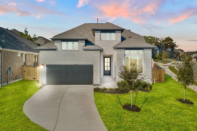 view of front of property featuring a lawn and a garage