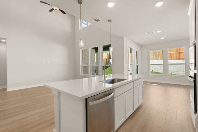 kitchen with appliances with stainless steel finishes, a kitchen island with sink, sink, decorative light fixtures, and white cabinets