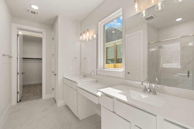 bathroom with vanity and a shower with door