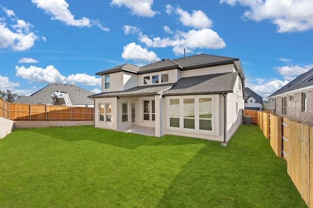 rear view of property featuring a yard, a patio, and central air condition unit