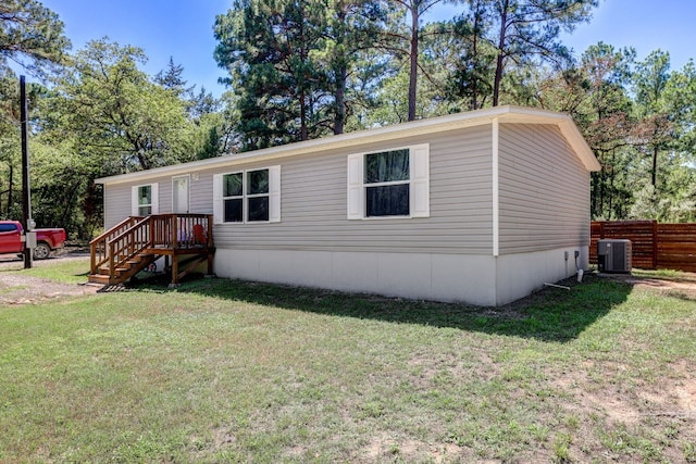 manufactured / mobile home with central AC and a front yard