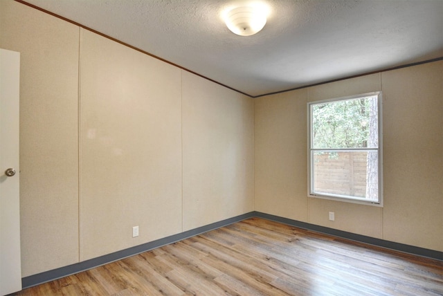 spare room featuring a textured ceiling and hardwood / wood-style floors