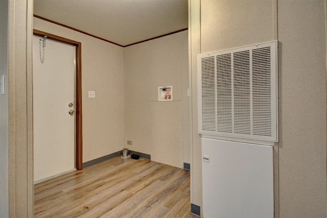 laundry area featuring washer hookup, light hardwood / wood-style floors, and a textured ceiling