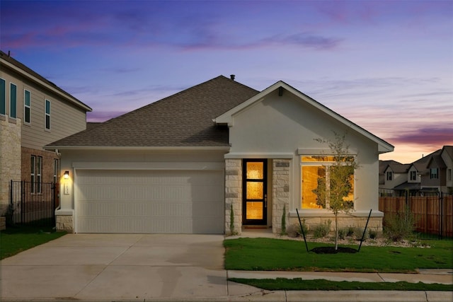 view of front of property with a garage and a yard