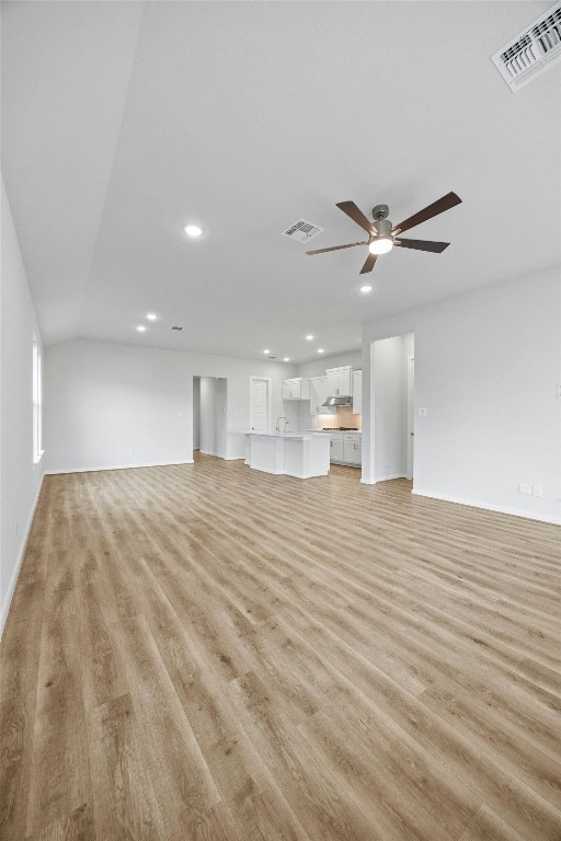 unfurnished living room with ceiling fan and light hardwood / wood-style flooring