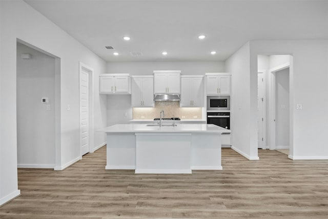 kitchen featuring white cabinets, an island with sink, and stainless steel appliances