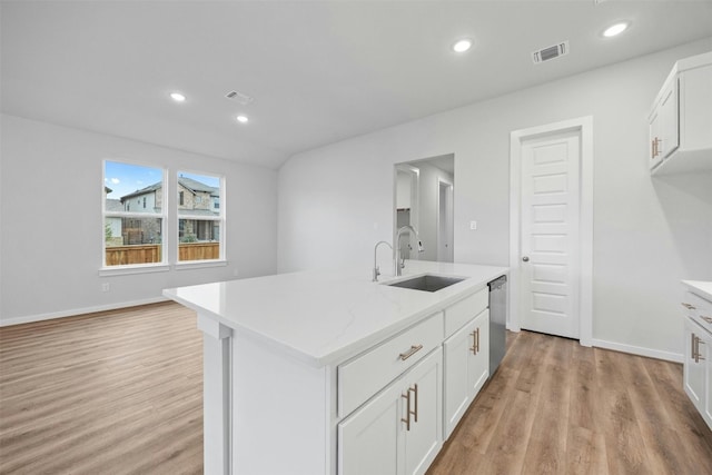 kitchen featuring dishwasher, a center island with sink, white cabinets, sink, and light wood-type flooring