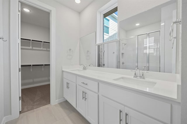 bathroom with vanity and a shower with shower door