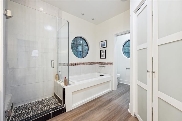 bathroom featuring hardwood / wood-style floors, separate shower and tub, and toilet