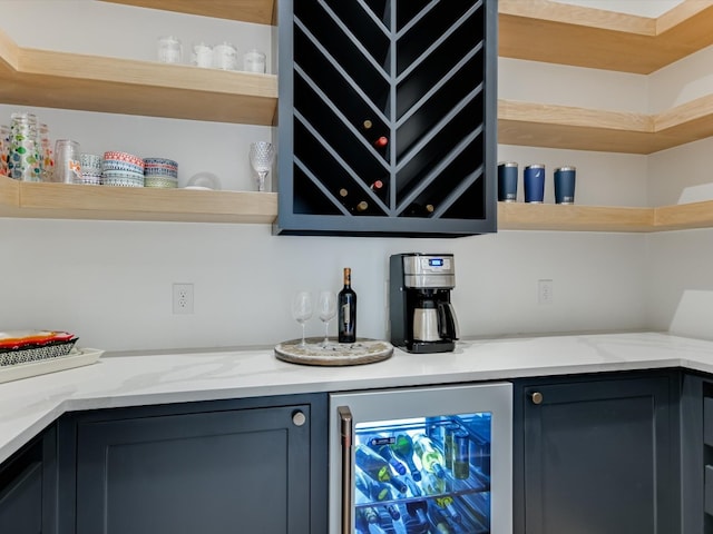 bar featuring wine cooler and light stone countertops