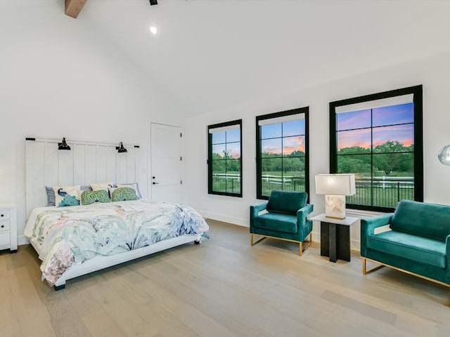 bedroom featuring light hardwood / wood-style floors and high vaulted ceiling