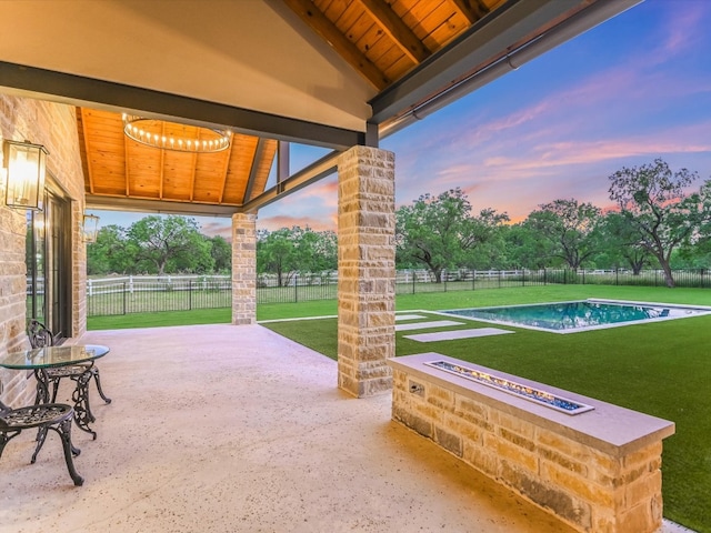 patio terrace at dusk featuring a yard