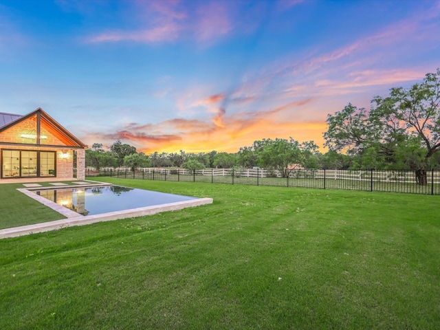 yard at dusk with a fenced in pool