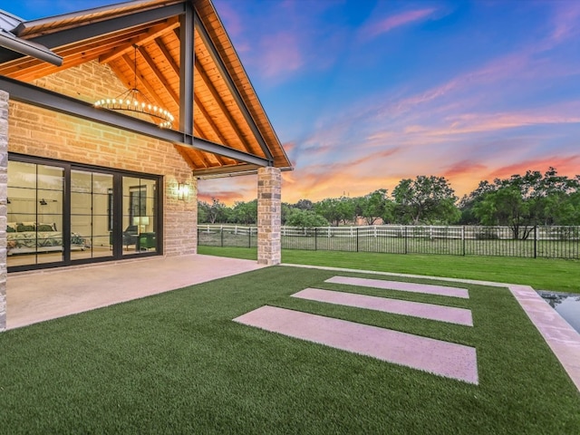 yard at dusk featuring a patio