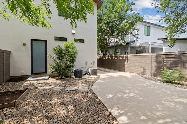 back of property with central AC and a patio area