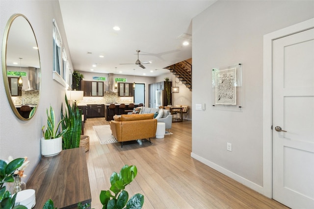 living room with ceiling fan and light hardwood / wood-style flooring