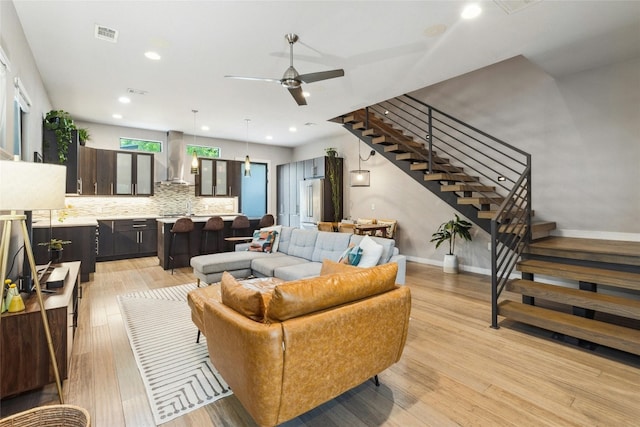 living room with light hardwood / wood-style floors and ceiling fan