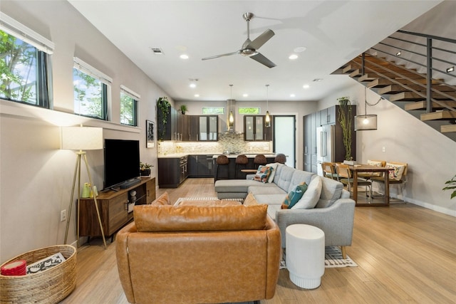 living room with a wealth of natural light, ceiling fan, and light hardwood / wood-style flooring