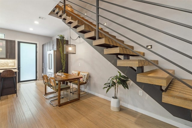 stairway with light hardwood / wood-style flooring