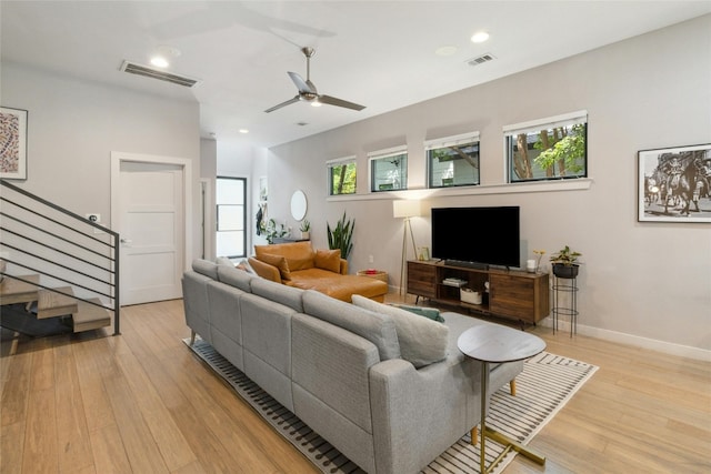 living room featuring a healthy amount of sunlight, ceiling fan, and light hardwood / wood-style flooring