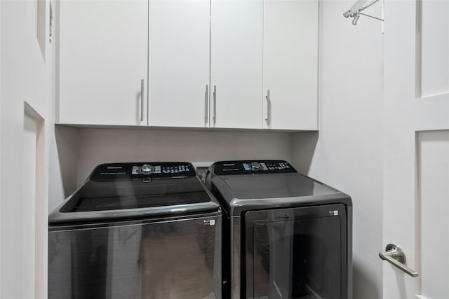 clothes washing area featuring cabinets, hookup for a washing machine, and washing machine and clothes dryer