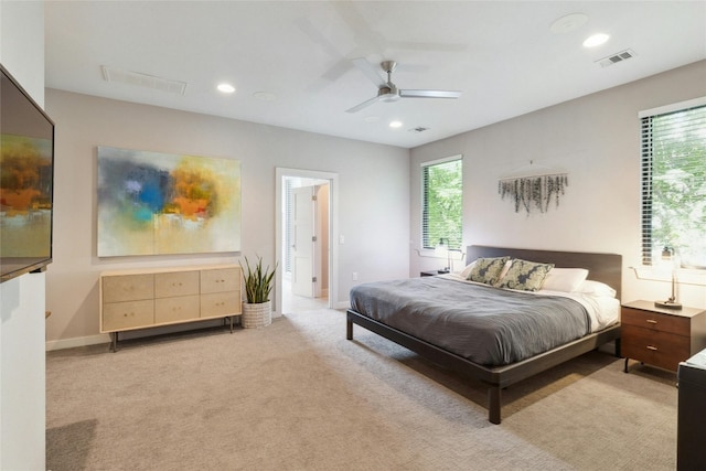 bedroom featuring multiple windows, light colored carpet, and ceiling fan