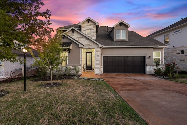 view of front of home with a garage and a lawn