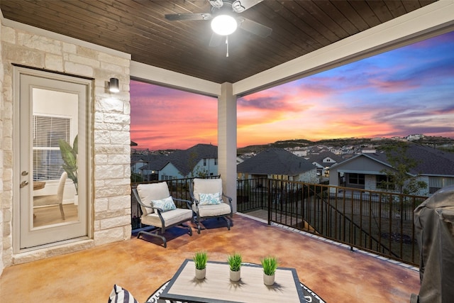 balcony at dusk featuring ceiling fan