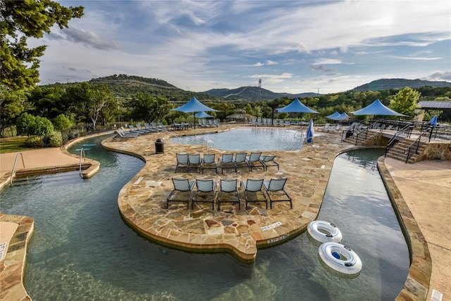 view of swimming pool with a mountain view and a patio