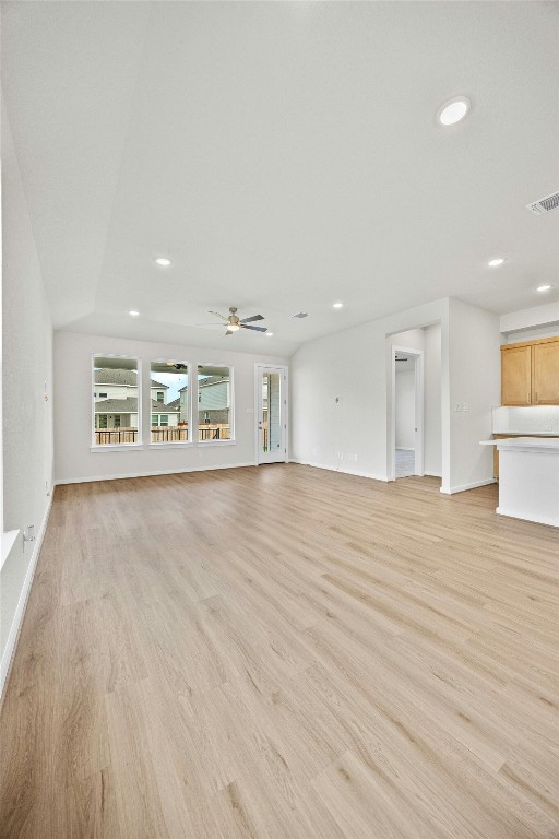 unfurnished living room with light wood-type flooring and ceiling fan