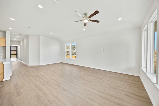 unfurnished living room featuring ceiling fan, light hardwood / wood-style flooring, and a healthy amount of sunlight