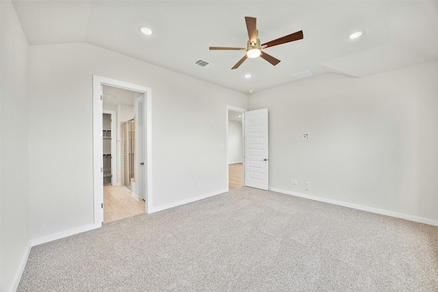 unfurnished bedroom featuring light carpet, vaulted ceiling, and ceiling fan