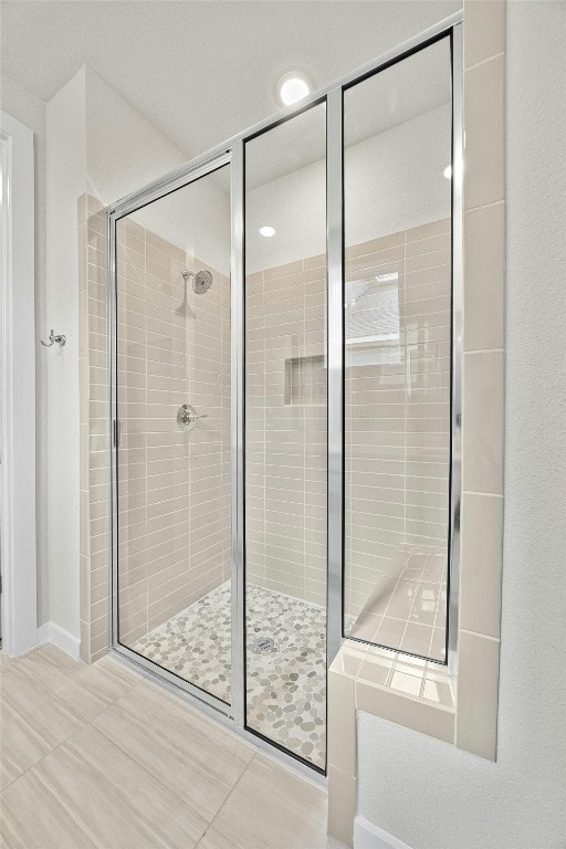 bathroom featuring tile patterned floors and a shower with shower door