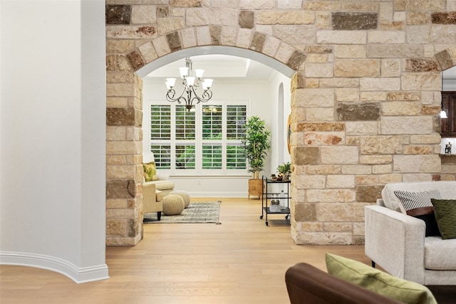 sitting room with hardwood / wood-style flooring, ornamental molding, and a notable chandelier