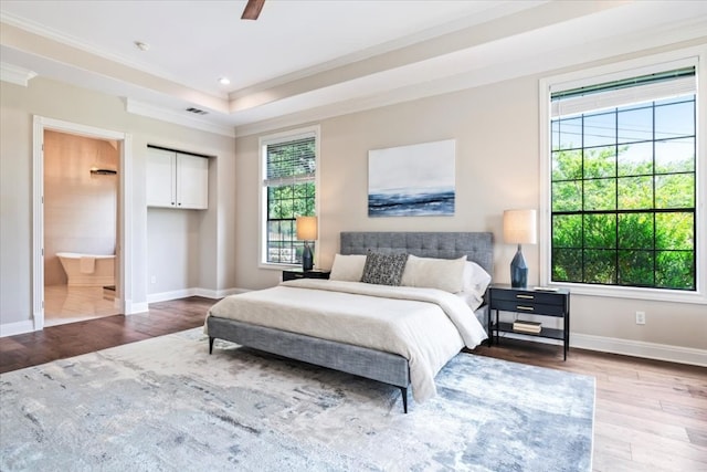 bedroom featuring ceiling fan, ensuite bathroom, light hardwood / wood-style floors, and crown molding