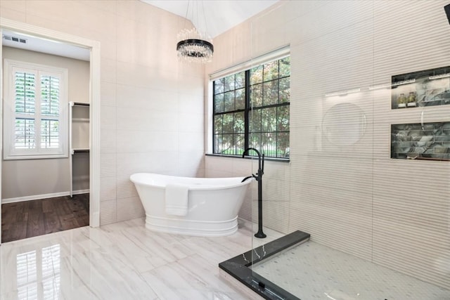 bathroom featuring tile walls, tile floors, and a bathing tub