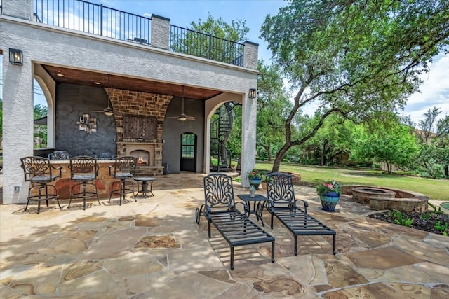 view of terrace featuring an outdoor fire pit and a balcony