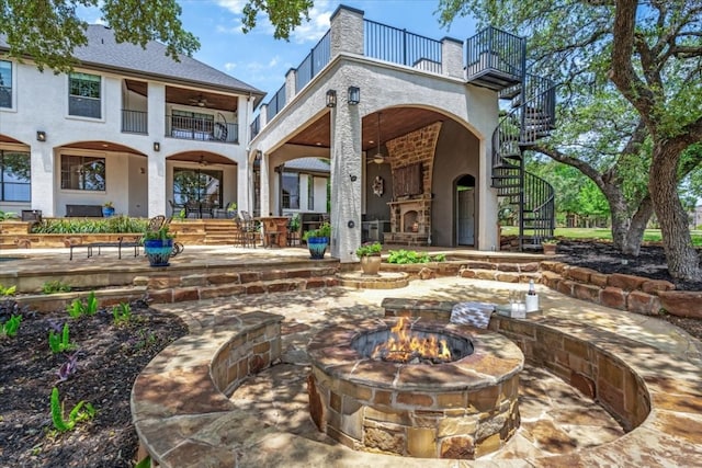 back of house with an outdoor fire pit, a balcony, and a patio