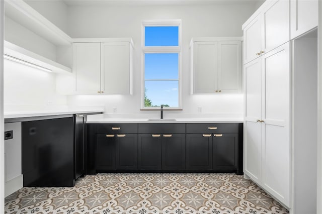 kitchen featuring a sink, white cabinetry, light countertops, dark cabinetry, and open shelves