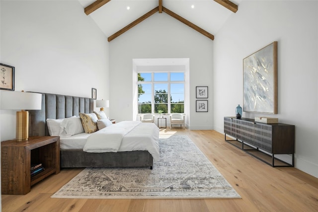 bedroom featuring high vaulted ceiling, wood finished floors, beam ceiling, and baseboards