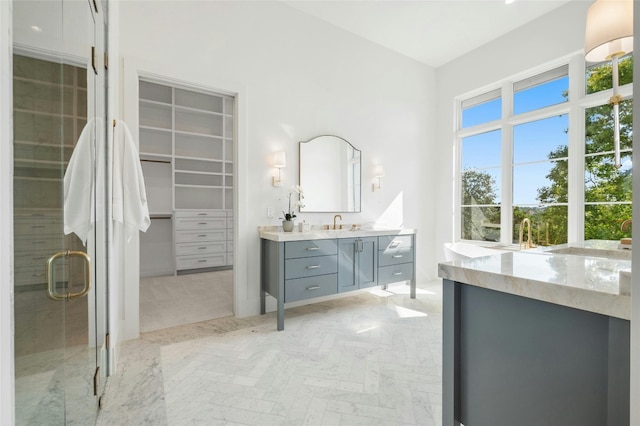 full bath featuring a stall shower, a walk in closet, and vanity