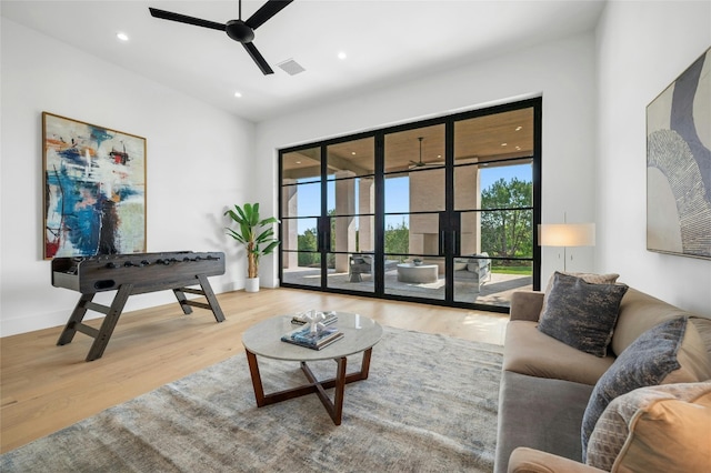 sitting room featuring plenty of natural light, visible vents, ceiling fan, and wood finished floors